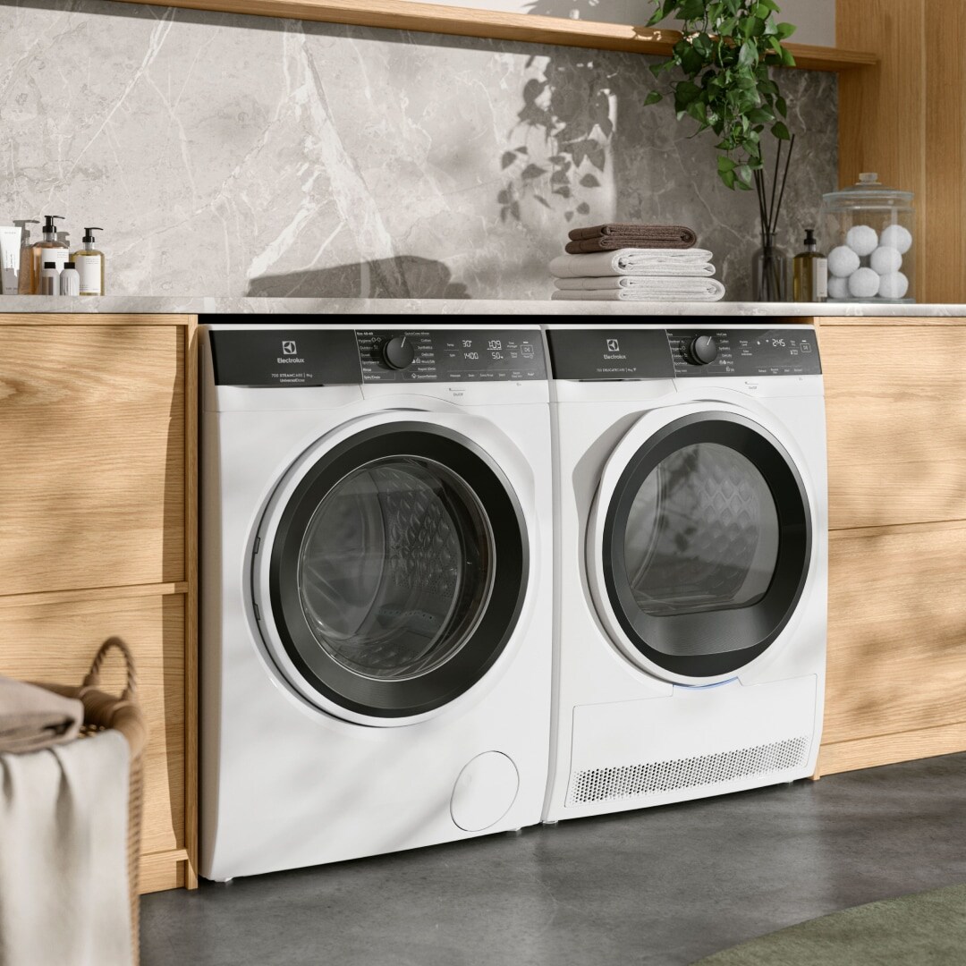 Tumble dryer and washing machine next to each other in a laundry room.