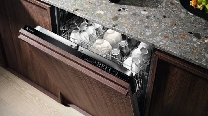 Close-up of open dishwasher with dishes